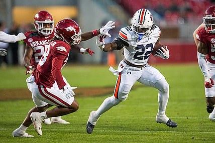 Nov 11, 2023; Fayetteville, Arkansas, USA;  Auburn Tigers running back Damari Alston (22) tries to fight off Arkansas Razorbacks defensive back TJ Metcalf (18) during the third quarter at Donald W. Reynolds Razorback Stadium. Auburn won 48-10. Mandatory Credit: Brett Rojo-USA TODAY Sports
