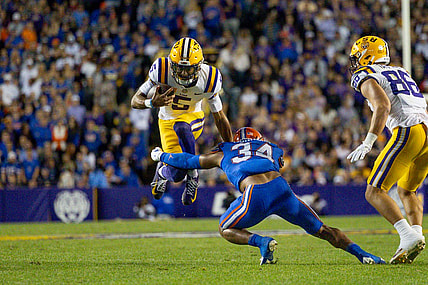 Nov 11, 2023; Baton Rouge, Louisiana, USA;  LSU Tigers quarterback Jayden Daniels (5) attempts to leap over the arms of Florida Gators linebacker Mannie Nunnery (34) during the first half at Tiger Stadium. Mandatory Credit: Stephen Lew-USA TODAY Sports