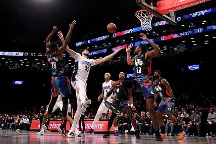 Nov 14, 2023; Brooklyn, New York, USA; Orlando Magic center Goga Bitadze (35) fights for a rebound against Brooklyn Nets forward Dorian Finney-Smith (28) and center Day'Ron Sharpe (20) during the second quarter at Barclays Center. Mandatory Credit: Brad Penner-USA TODAY Sports
