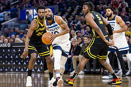 Nov 14, 2023; San Francisco, California, USA; Minnesota Timberwolves guard Mike Conley (10) prepares to shoot in front of Golden State Warriors forward Kevon Looney (5) and forward Andrew Wiggins (22) during the first half at Chase Center. Mandatory Credit: John Hefti-USA TODAY Sports