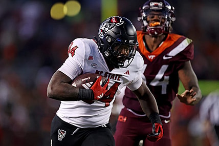 Nov 18, 2023; Blacksburg, Virginia, USA; North Carolina State Wolfpack running back Delbert Mimms III (34) runs the ball against Virginia Tech Hokies linebacker Alan Tisdale (34) during the third quarter at Lane Stadium. Mandatory Credit: Peter Casey-USA TODAY Sports