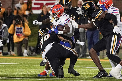 Nov 18, 2023; Columbia, Missouri, USA; Florida Gators running back Trevor Etienne (7) runs the ball as Missouri Tigers linebacker Chuck Hicks (30) makes the tackle during the first half at Faurot Field at Memorial Stadium. Mandatory Credit: Denny Medley-USA TODAY Sports