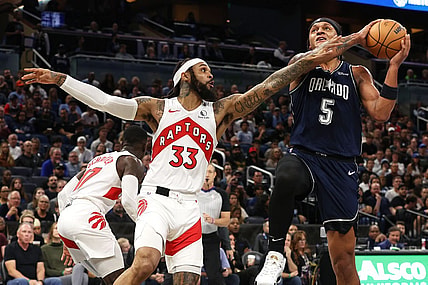 Nov 21, 2023; Orlando, Florida, USA; Orlando Magic forward Paolo Banchero (5) shoots as Toronto Raptors guard Gary Trent Jr. (33) defends during the first quarter at Amway Center. Mandatory Credit: Kim Klement Neitzel-USA TODAY Sports