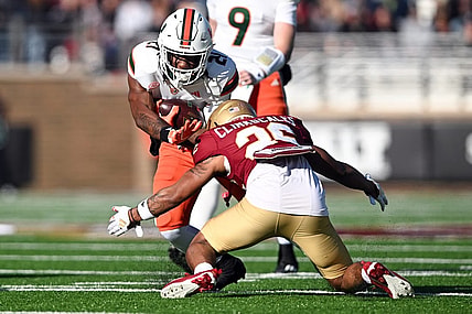 Nov 24, 2023; Chestnut Hill, Massachusetts, USA; Miami Hurricanes running back Henry Parrish Jr. (21) runs against Boston College Eagles defensive back CJ Clinkscales (26) during the first half at Alumni Stadium. Mandatory Credit: Brian Fluharty-USA TODAY Sports