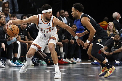 Nov 24, 2023; Memphis, Tennessee, USA; Phoenix Suns guard Devin Booker (1) dribbles as Memphis Grizzlies guard Jacob Gilyard (0) defends during the second half at FedExForum. Mandatory Credit: Petre Thomas-USA TODAY Sports