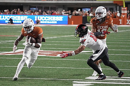Nov 24, 2023; Austin, Texas, USA; Texas Longhorns running back Keilan Robinson (7) runs for a touchdown while defended by Texas Tech Red Raiders defensive back Bralyn Lux (12) during the first half at Darrell K Royal-Texas Memorial Stadium. Mandatory Credit: Scott Wachter-USA TODAY Sports