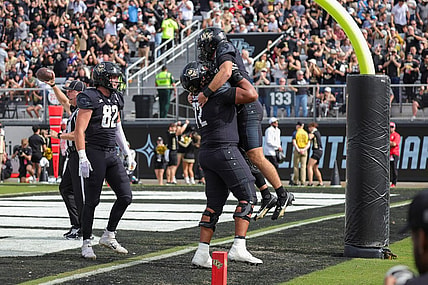 Nov 25, 2023; Orlando, Florida, USA; UCF Knights quarterback John Rhys Plumlee (10) is lifted into the air by offensive lineman Marcellus Marshall (72) after scoring against the Houston Cougars during the first quarter at FBC Mortgage Stadium. Mandatory Credit: Mike Watters-USA TODAY Sports
