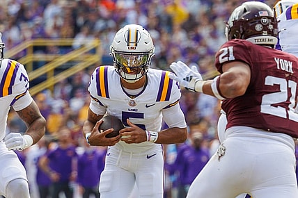 Nov 25, 2023; Baton Rouge, Louisiana, USA;  LSU Tigers quarterback Jayden Daniels (5) rushes against Texas A&M Aggies linebacker Taurean York (21) during the first half at Tiger Stadium. Mandatory Credit: Stephen Lew-USA TODAY Sports
