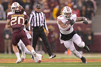 Nov 25, 2023; Minneapolis, Minnesota, USA;  Wisconsin Badgers running back Braelon Allen (0) runs with the ball as quarterback Tanner Mordecai (8) puts a block on Minnesota Golden Gophers defensive back Jack Henderson (20) at Huntington Bank Stadium. Mandatory Credit: Nick Wosika-USA TODAY Sports
