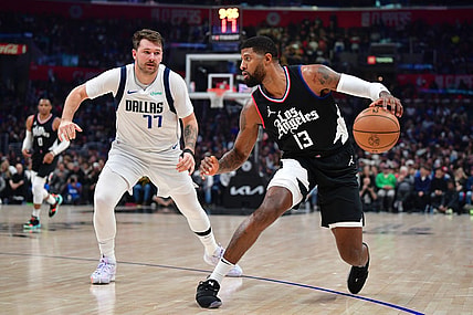 Nov 25, 2023; Los Angeles, California, USA; Los Angeles Clippers forward Paul George (13) moves the ball against Dallas Mavericks guard Luka Doncic (77) during the first half at Crypto.com Arena. Mandatory Credit: Gary A. Vasquez-USA TODAY Sports