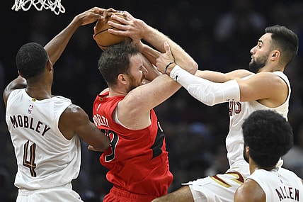 Nov 26, 2023; Cleveland, Ohio, USA; Cleveland Cavaliers forward Evan Mobley (4) and guard Max Strus (1) defend Toronto Raptors center Jakob Poeltl (19) in the second quarter at Rocket Mortgage FieldHouse. Mandatory Credit: David Richard-USA TODAY Sports