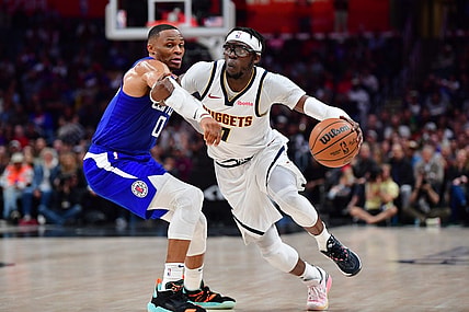 Nov 27, 2023; Los Angeles, California, USA; Denver Nuggets guard Reggie Jackson (7) moves the ball against Los Angeles Clippers guard Russell Westbrook (0) during the second half at Crypto.com Arena. Mandatory Credit: Gary A. Vasquez-USA TODAY Sports