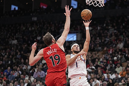Nov 29, 2023; Toronto, Ontario, CAN; Phoenix Suns guard Devin Booker (1) shoots the ball as Toronto Raptors center Jakob Poeltl (19) defends during the first half at Scotiabank Arena. Mandatory Credit: John E. Sokolowski-USA TODAY Sports