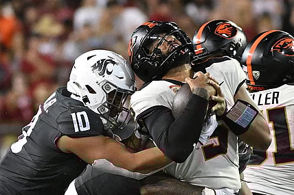 Sep 23, 2023; Pullman, Washington, USA; Oregon State Beavers quarterback DJ Uiagalelei (5) is stopped by Washington State Cougars defensive end Ron Stone Jr. (10) in the second half at Gesa Field at Martin Stadium. Mandatory Credit: James Snook-USA TODAY Sports