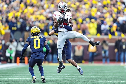 Ohio State wide receiver Marvin Harrison Jr. makes a catch against Michigan defensive backs Quinten Johnson and Mike Sainristil during the second half at Michigan Stadium in Ann Arbor on Saturday, Nov. 25, 2023.