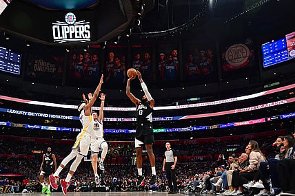 Dec 2, 2023; Los Angeles, California, USA; Los Angeles Clippers forward Paul George (13) shoots against Golden State Warriors guard Moses Moody (4) during the second half at Crypto.com Arena. Mandatory Credit: Gary A. Vasquez-USA TODAY Sports
