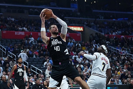 Dec 6, 2023; Los Angeles, California, USA; LA Clippers center Ivica Zubac (40) shoots the ball against Denver Nuggets guard Reggie Jackson (7) in the first half at Crypto.com Arena. Mandatory Credit: Kirby Lee-USA TODAY Sports