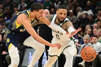 Dec 13, 2023; Milwaukee, Wisconsin, USA; Indiana Pacers guard Tyrese Haliburton (0) and Milwaukee Bucks guard Damian Lillard (0) reach for a loose ball in the first quarter at Fiserv Forum. Mandatory Credit: Benny Sieu-USA TODAY Sports