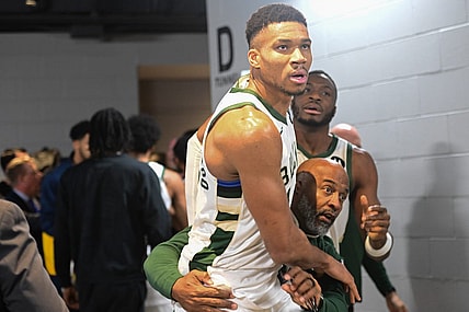 Dec 13, 2023; Milwaukee, Wisconsin, USA;  Milwaukee Bucks forward Giannis Antetokounmpo (34) is restrained by a coach outside the Indiana Pacers locker room after the game at Fiserv Forum. Mandatory Credit: Benny Sieu-USA TODAY Sports