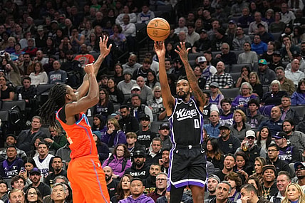 Dec 14, 2023; Sacramento, California, USA; Sacramento Kings guard Malik Monk (0) shoots against Oklahoma City Thunder guard Cason Wallace (left) during the second quarter at Golden 1 Center. Mandatory Credit: Darren Yamashita-USA TODAY Sports