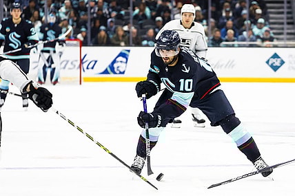 Dec 16, 2023; Seattle, Washington, USA; Seattle Kraken center Matty Beniers (10) flips the puck forward against the Los Angeles Kings during the second period at Climate Pledge Arena. Mandatory Credit: Joe Nicholson-USA TODAY Sports