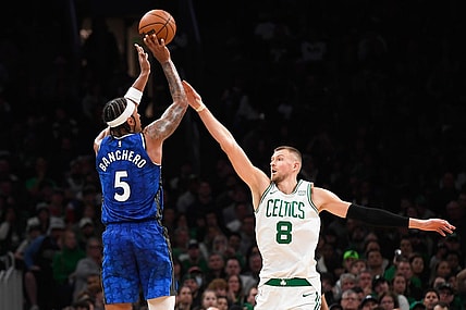 Dec 17, 2023; Boston, Massachusetts, USA;  Orlando Magic forward Paolo Banchero (5) shoots the ball over Boston Celtics center Kristaps Porzingis (8) during the second half at TD Garden. Mandatory Credit: Bob DeChiara-USA TODAY Sports