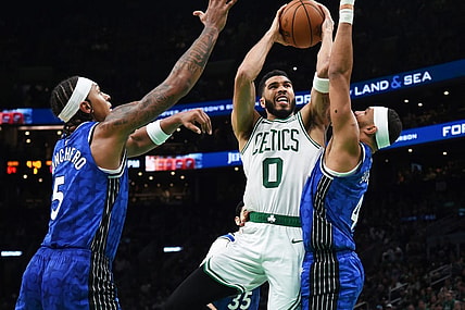 Dec 17, 2023; Boston, Massachusetts, USA;  Boston Celtics forward Jayson Tatum (0) drives to the basket between Orlando Magic forward Paolo Banchero (5) and guard Jalen Suggs (4) during the second half at TD Garden. Mandatory Credit: Bob DeChiara-USA TODAY Sports