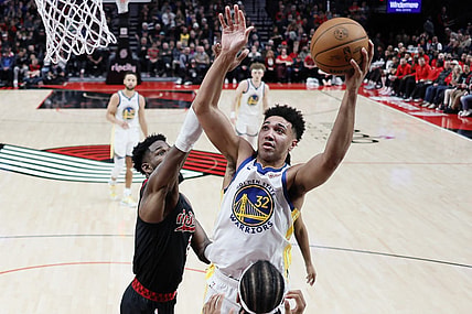 Dec 17, 2023; Portland, Oregon, USA; Golden State Warriors forward Trayce Jackson-Davis (32) shoots the ball over Portland Trail Blazers center Deandre Anton (2, left) during the second half at Moda Center. Mandatory Credit: Soobum Im-USA TODAY Sports