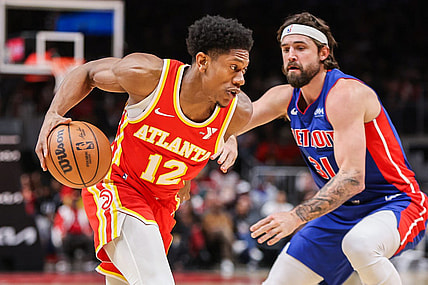 Dec 18, 2023; Atlanta, Georgia, USA; Atlanta Hawks forward De'Andre Hunter (12) drives on Detroit Pistons forward Joe Harris (31) in the second quarter at State Farm Arena. Mandatory Credit: Brett Davis-USA TODAY Sports