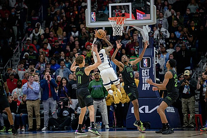 Dec 19, 2023; New Orleans, Louisiana, USA; Memphis Grizzlies guard Ja Morant (12) attempts the game winning basket against New Orleans Pelicans guard Dyson Daniels (11) and forward Herbert Jones (5) during the fourth quarter against the New Orleans Pelicans at the Smoothie King Center. Mandatory Credit: Matthew Hinton-USA TODAY Sports