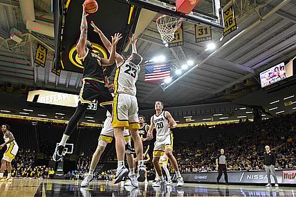Dec 20, 2023; Iowa City, Iowa, USA; UMBC Retrievers center Max Lorca-Lloyd (5) shoots the ball over Iowa Hawkeyes forward Ben Krikke (23) and forward Payton Sandfort (20) defend during the first half at Carver-Hawkeye Arena. Mandatory Credit: Jeffrey Becker-USA TODAY Sports
