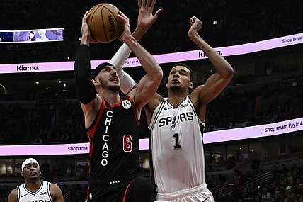 Dec 21, 2023; Chicago, Illinois, USA;  Chicago Bulls guard Alex Caruso (6) shoots against San Antonio Spurs center Victor Wembanyama (1) during the first half at the United Center. Mandatory Credit: Matt Marton-USA TODAY Sports