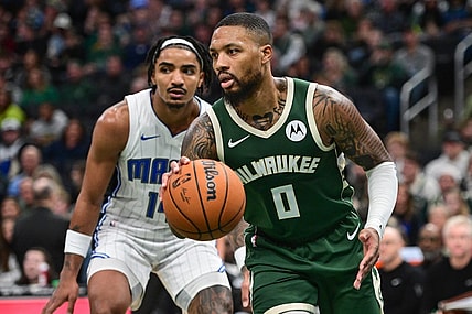 Dec 21, 2023; Milwaukee, Wisconsin, USA;  Milwaukee Bucks guard Damian Lillard (0) drives past Orlando Magic guard Gary Harris (14) in the fourth quarter at Fiserv Forum. Mandatory Credit: Benny Sieu-USA TODAY Sports