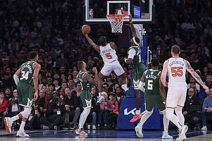 Dec 25, 2023; New York, New York, USA; New York Knicks guard Immanuel Quickley (5) drives to the basket as Milwaukee Bucks forward Bobby Portis (9) and guard Damian Lillard (0) defend during the second half at Madison Square Garden. Mandatory Credit: Vincent Carchietta-USA TODAY Sports