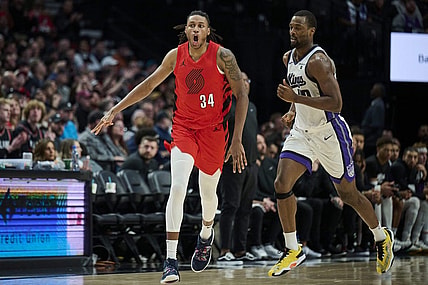 Dec 26, 2023; Portland, Oregon, USA; Portland Trail Blazers forward Jabari Walker (34) celebrates making a three point basket during the second half against Sacramento Kings forward Harrison Barnes (40) at Moda Center. Mandatory Credit: Troy Wayrynen-USA TODAY Sports