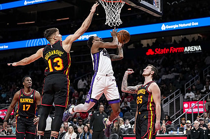 Dec 29, 2023; Atlanta, Georgia, USA; Sacramento Kings guard Malik Monk (0) tries to score past Atlanta Hawks guard Bogdan Bogdanovic (13) during the first half at State Farm Arena. Mandatory Credit: Dale Zanine-USA TODAY Sports