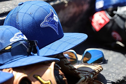 Mar 18, 2022; Sarasota, Florida, USA; A detail view of a Toronto Blue Jays hat and glove in the dugout during spring training against the Baltimore Orioles at Ed Smith Stadium. Mandatory Credit: Kim Klement-USA TODAY Sports