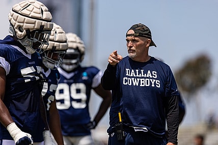 Aug 4, 2022; Oxnard, CA, USA; Dallas Cowboys defensive coordinator Dan Quinn talks to players during training camp at River Ridge Playing Fields in Oxnard, California. Mandatory Credit: Jason Parkhurst-USA TODAY Sports