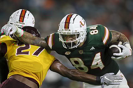 Sep 14, 2023; Miami Gardens, Florida, USA; Miami Hurricanes tight end Cam McCormick (84) runs with the football against Bethune Cookman Wildcats cornerback Stephen Sparrow (27) during the first quarter at Hard Rock Stadium. Mandatory Credit: Sam Navarro-USA TODAY Sports