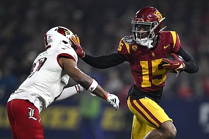 Dec 27, 2023; San Diego, CA, USA; USC Trojans wide receiver Dorian Singer (15) stiff arms Louisville Cardinals defensive back Devin Neal (27) during the first half at Petco Park. Mandatory Credit: Orlando Ramirez-USA TODAY Sports