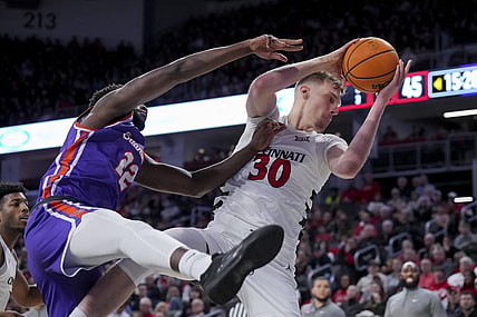 Dec 29, 2023; Cincinnati, Ohio, USA;  Cincinnati Bearcats forward Viktor Lakhin (30) grabs a rebound against Evansville Aces forward Sekou Kalle (22) in the second half at Fifth Third Arena. Mandatory Credit: Aaron Doster-USA TODAY Sports