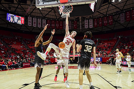 Dec 31, 2023; Salt Lake City, Utah, USA; Utah Utes center Branden Carlson (35) hangs onto the basket after dunking over Washington Huskies forward Wilhelm Breidenbach (32) during the second half at the the Jon M. Huntsman Center. Mandatory Credit: Christopher Creveling-USA TODAY Sports