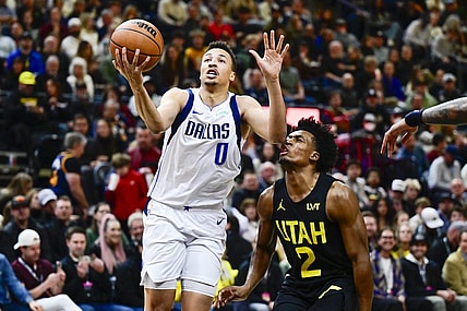 Jan 1, 2024; Salt Lake City, Utah, USA; Dallas Mavericks guard Dante Exum (0) takes a shot in front of Utah Jazz guard Collin Sexton (2) during the first half at the Delta Center. Mandatory Credit: Christopher Creveling-USA TODAY Sports