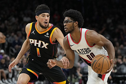 Jan 1, 2024; Phoenix, Arizona, USA; Portland Trail Blazers guard Scoot Henderson (00) drives on Phoenix Suns guard Devin Booker (1) in the second half at Footprint Center. Mandatory Credit: Rick Scuteri-USA TODAY Sports