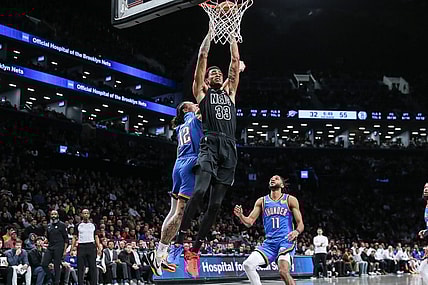 Jan 5, 2024; Brooklyn, New York, USA;  Brooklyn Nets center Nic Claxton (33) dunks past Oklahoma City Thunder forward Lindy Waters III (12) in the second quarter at Barclays Center. Mandatory Credit: Wendell Cruz-USA TODAY Sports