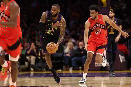 Jan 9, 2024; Los Angeles, California, USA; Los Angeles Lakers forward LeBron James (23) picks up a loose ball ahead of Toronto Raptors forward Thaddeus Young (21) during the second quarter at Crypto.com Arena. Mandatory Credit: Kiyoshi Mio-USA TODAY Sports