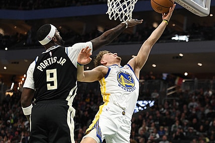 Jan 13, 2024; Milwaukee, Wisconsin, USA; Golden State Warriors guard Brandin Podziemski (2) puts up a shot against Milwaukee Bucks forward Bobby Portis (9) in the first half at Fiserv Forum. Mandatory Credit: Michael McLoone-USA TODAY Sports
