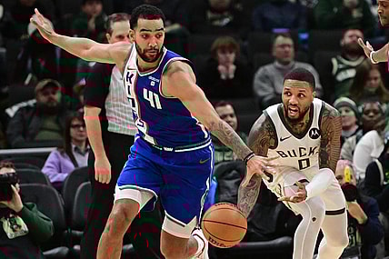 Jan 14, 2024; Milwaukee, Wisconsin, USA;  Milwaukee Bucks guard Damian Lillard (0) passes the ball away from Sacramento Kings forward Trey Lyles (41) in overtime at Fiserv Forum. Mandatory Credit: Benny Sieu-USA TODAY Sports