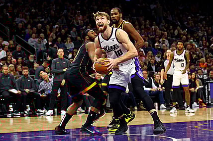 Jan 16, 2024; Phoenix, Arizona, USA; Sacramento Kings forward Domantas Sabonis (10) drives to the basket against Phoenix Suns forward Josh Okogie (2) and forward Nassir Little (25) during the fourth quarter at Footprint Center. Mandatory Credit: Mark J. Rebilas-USA TODAY Sports