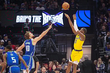 Jan 18, 2024; Sacramento, California, USA; Indiana Pacers guard Bennedict Mathurin (00) takes a shot over Sacramento Kings forward Domantas Sabonis (10) during the first quarter at Golden 1 Center. Mandatory Credit: Ed Szczepanski-USA TODAY Sports